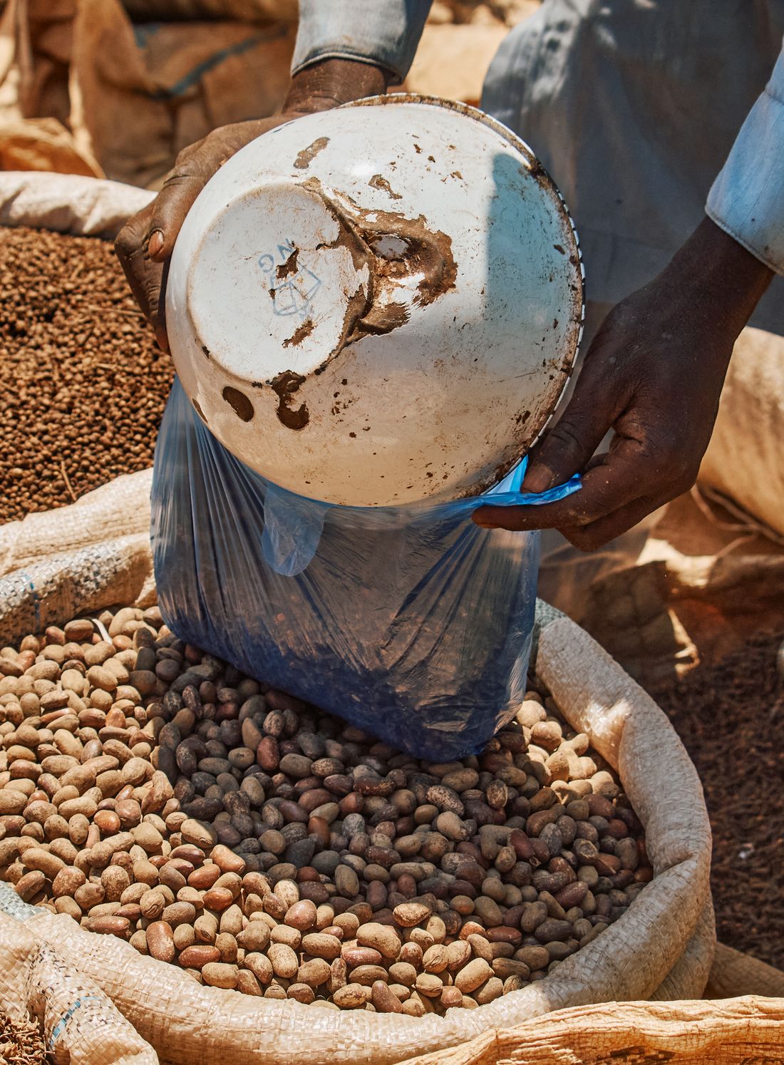Grain being measured and bagged at an open market.